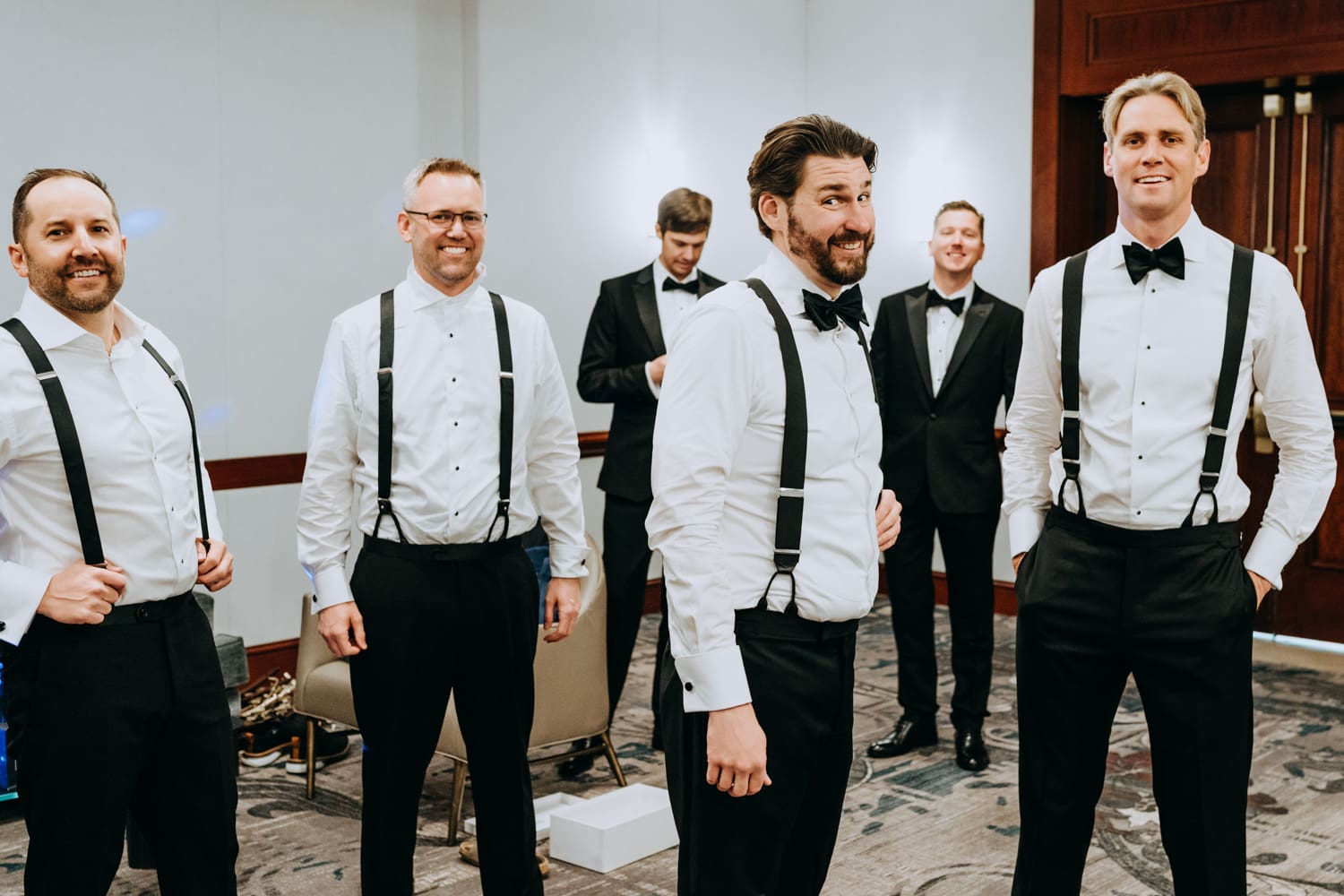 Groom getting ready with groomsmen in a Palace Hotel San Francisco hotel room