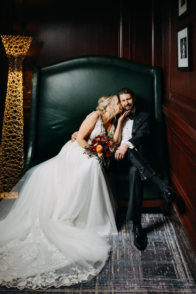 Bride and groom sitting in green leather chairs at the Pied Piper Bar Palace Hotel