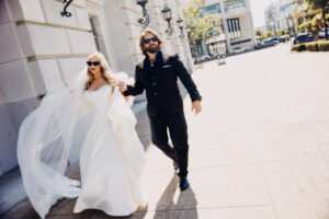 couple walking near Civic Center gates City Hall wedding