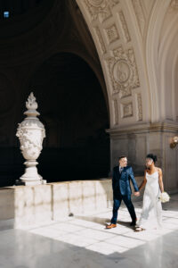 couple walking along windows fourth floor City Hall