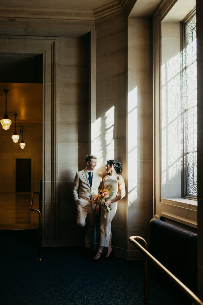 Couple in moody window light on the 2nd floor of San Francisco City Hall