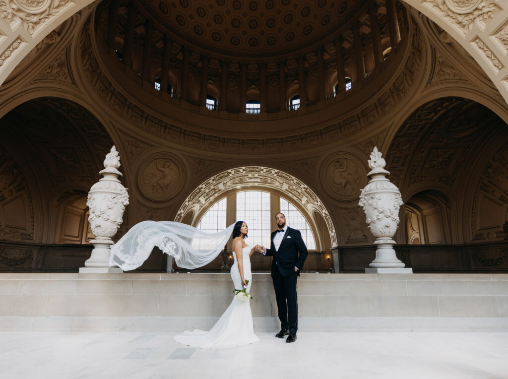 Black couple holding hands on the 4th floor gallery of San Francisco City Hall in the morning