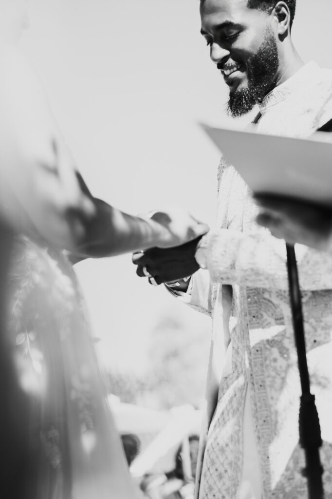 Close-up of the couple's hands during their wedding ring exchange at a vineyard ceremony.