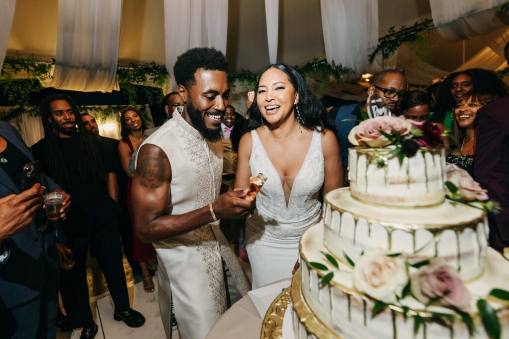 Black bride and groom cutting their wedding cake in the middle of the dance floor at Lavanda Leal Vineyards.