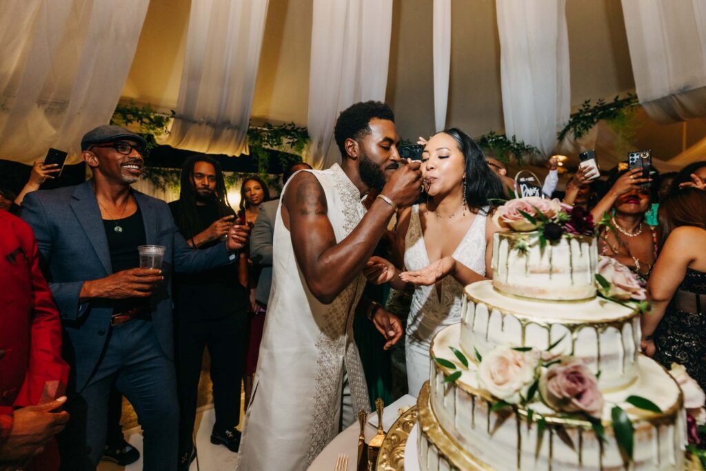 Black bride and groom cutting their wedding cake in the middle of the dance floor at Lavanda Leal Vineyards.