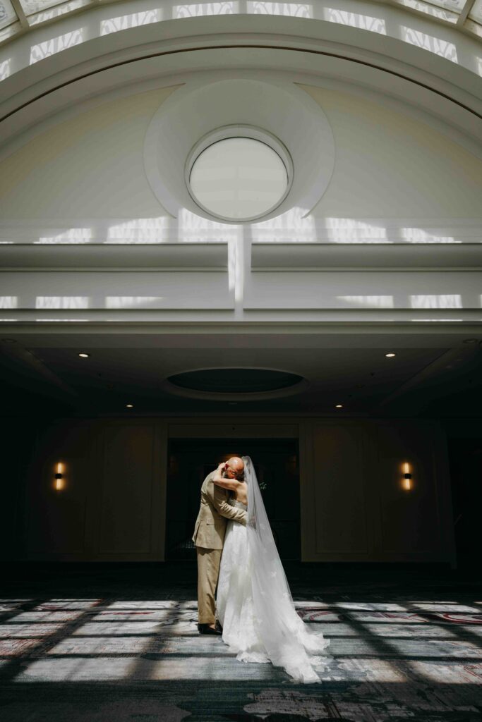 A bride and groom having an intimate moment after their ceremony in the Sunset Room of the Palace Hotel