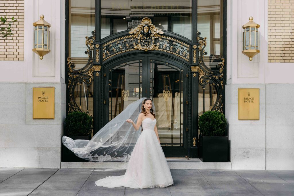 A bride standing in front of the doors at the Palace Hotel
